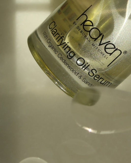 Heaven Clarifying Oil Serum bottle on a reflective surface