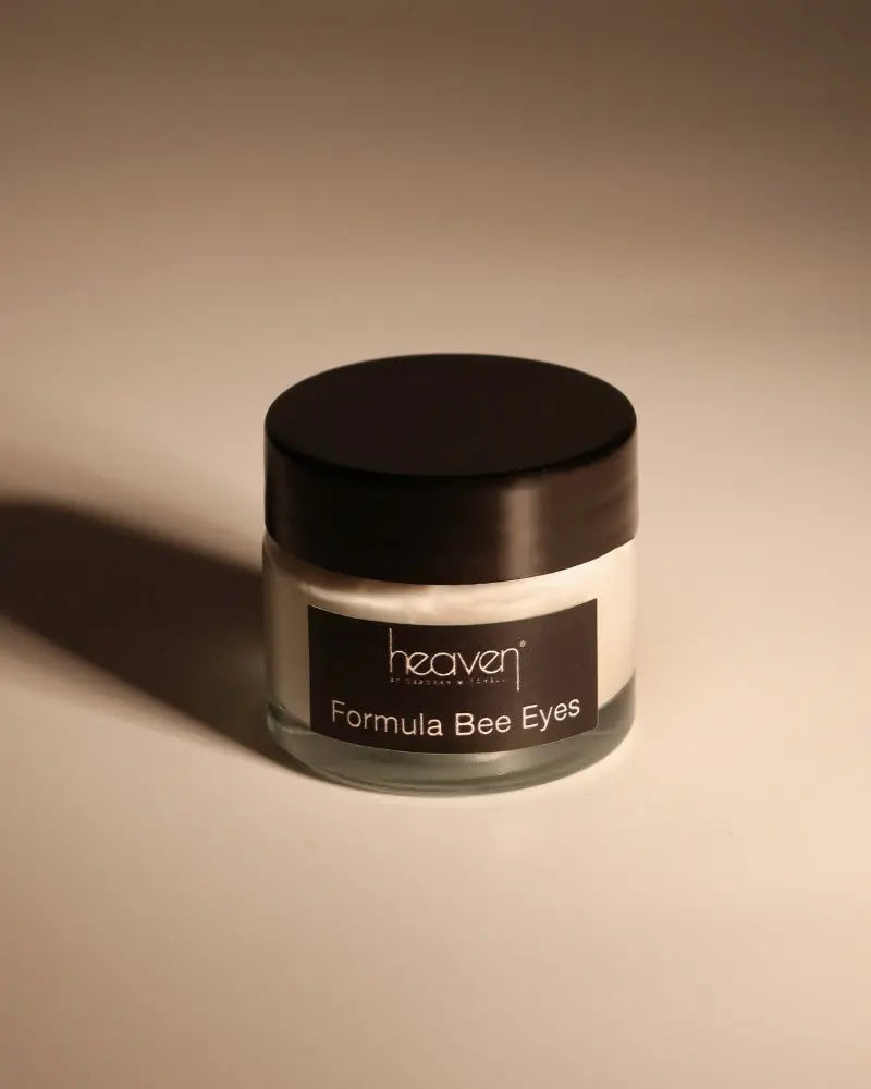 Heaven Formula Bee Eyes eye cream in a clear glass jar with a black lid and label.