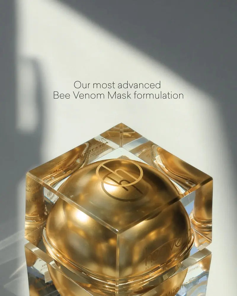 Gold cosmetic container with 'Our most advanced Bee Venom Mask formulation' text on a gray background