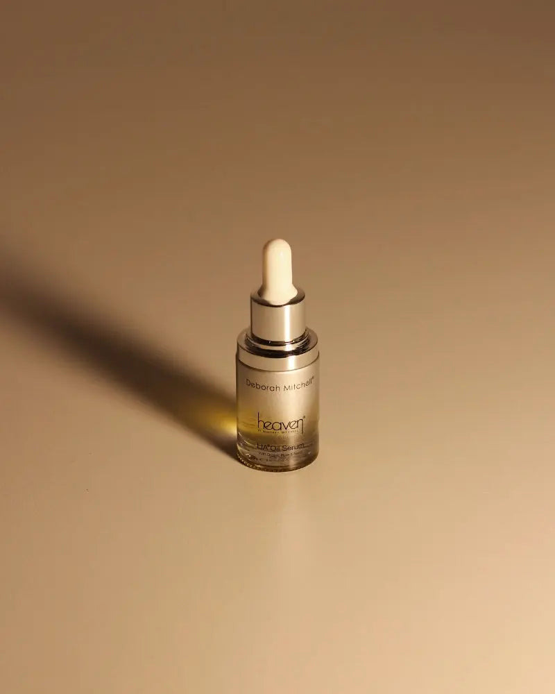 LIA Oil Serum bottle with silver cap and white pipette on a beige background