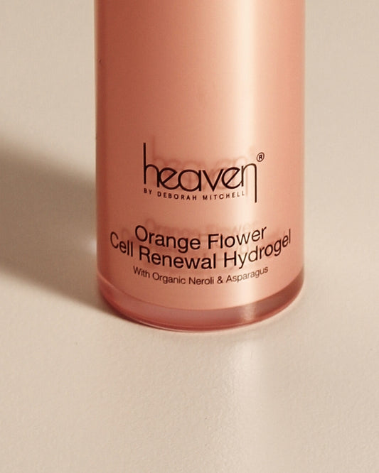 Orange flower cell renewal hydrogel upclose product shot. Orange bottle appears on a beige background.