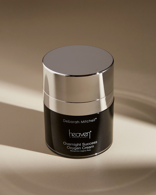 Cosmetic jar labeled 'Deborah Mitchell Heaven Overnight Success Oxygen Cream' on a beige background