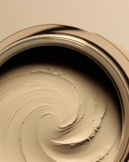 Close-up of a can of beige product with a swirl pattern.