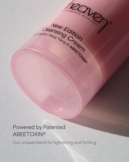 Pink cleansing cream container with text on a light gray background