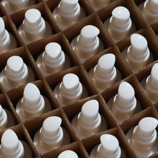Lots of white pump bottles wrapped in cardboard boxes