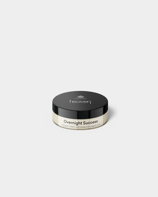 Overnight Success oxygen cream in a clear glass jar with a black lid, featuring botanical organic rose.