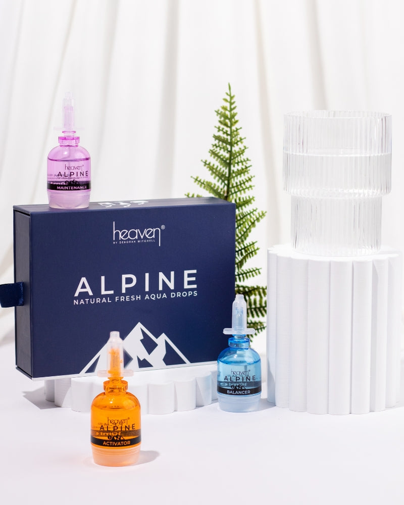 Heaven Alpine skincare products including bottles and a box on a white background with fern tree in the background
